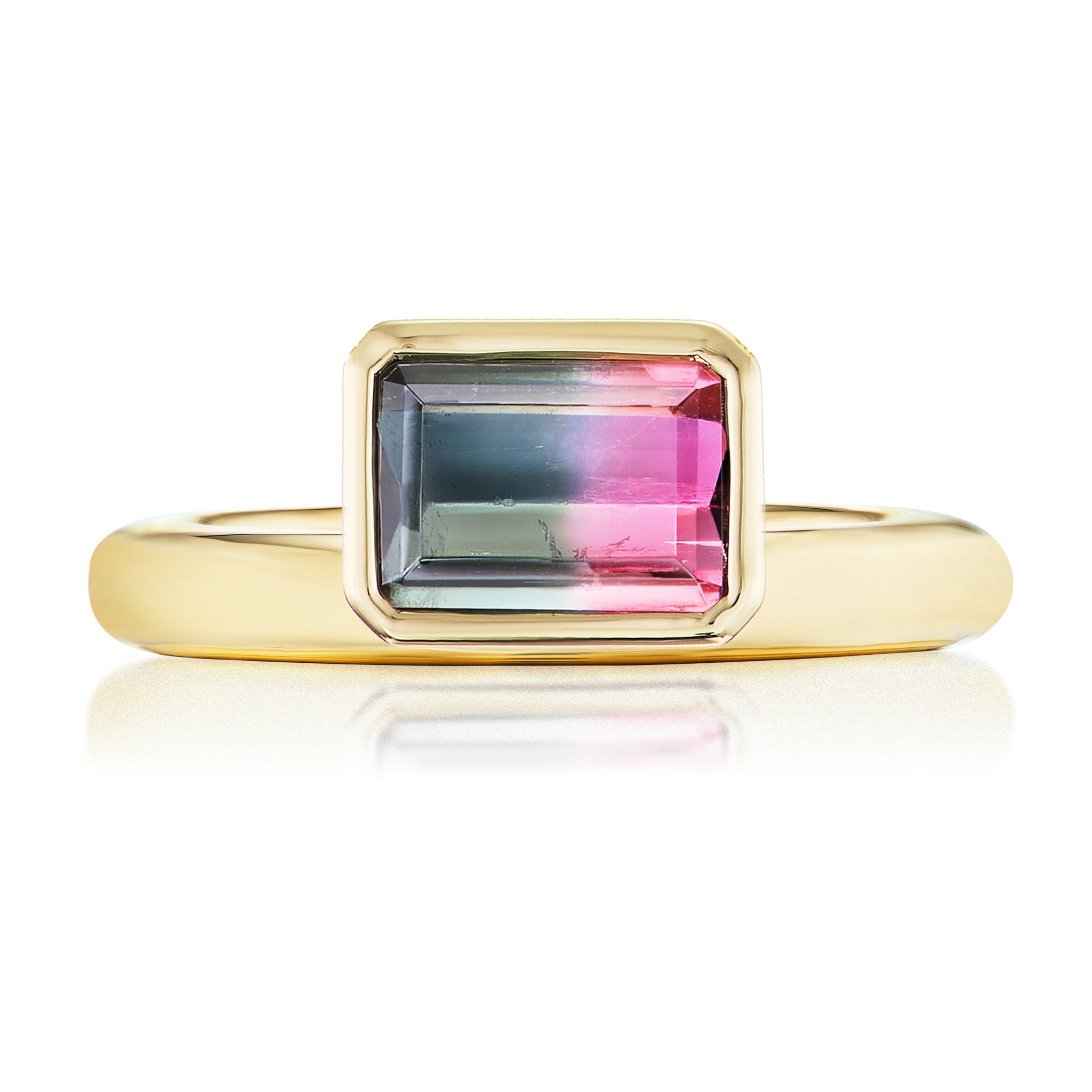 The Pinky Ring in Yellow Gold features an emerald cut watermelon tourmaline with green and pink hues, set in a simple 18K yellow gold bezel.