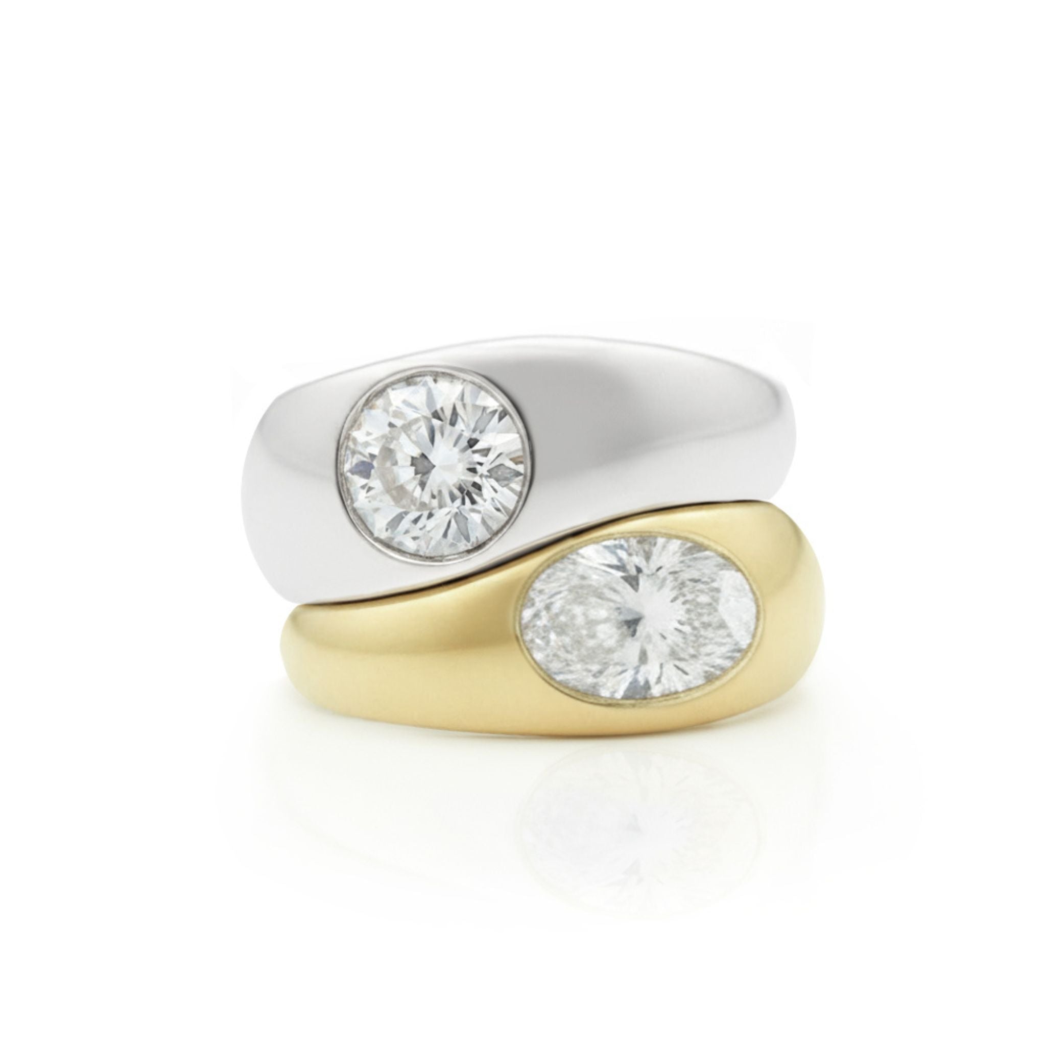 The Stacked Burnish Set features a round diamond in white gold and an oval diamond in yellow gold, both showcased against a white background.