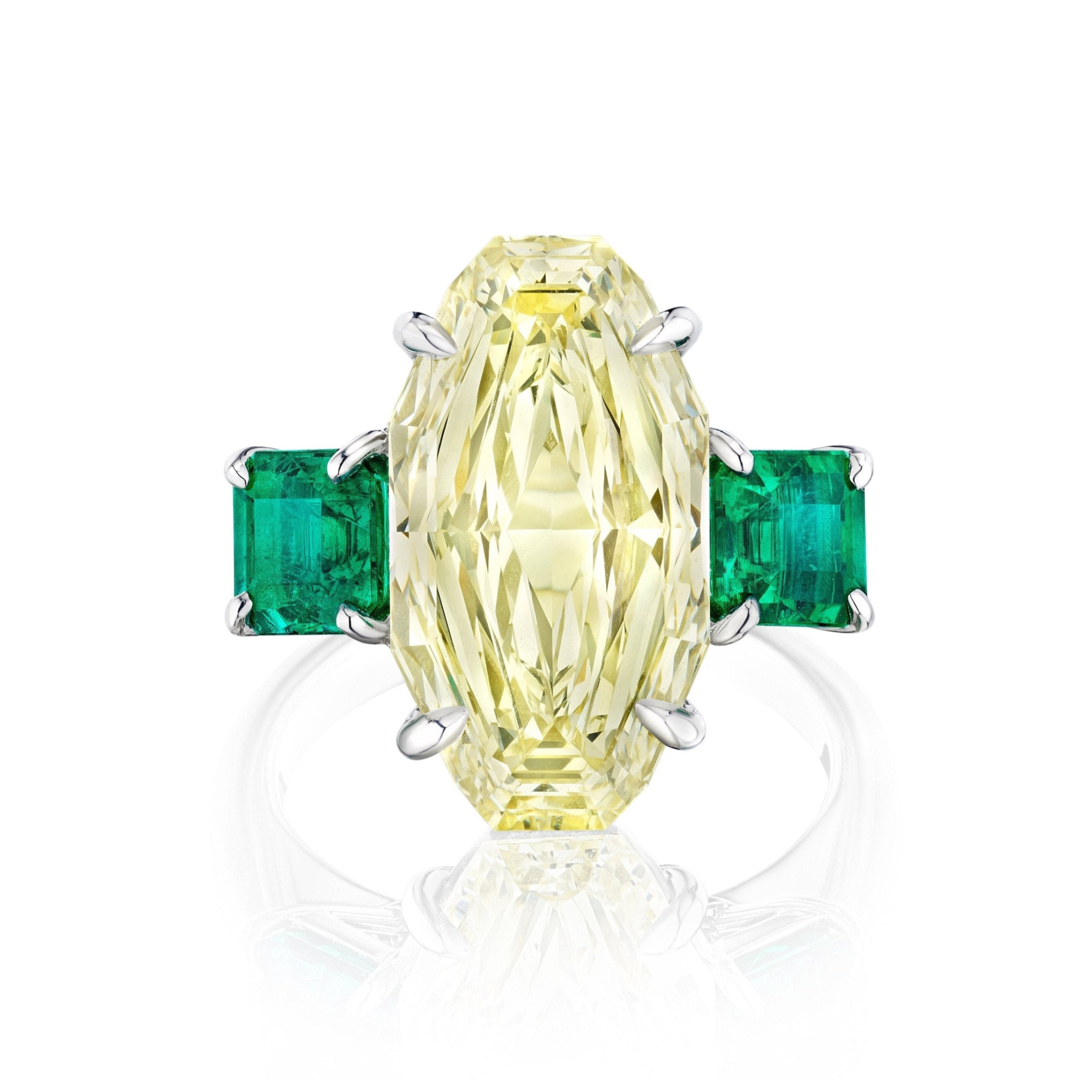 The Step Cut Oval Yellow Diamond Engagement Ring features a center oval yellow diamond with square emerald side stones, all set in a polished 18K white gold band.
