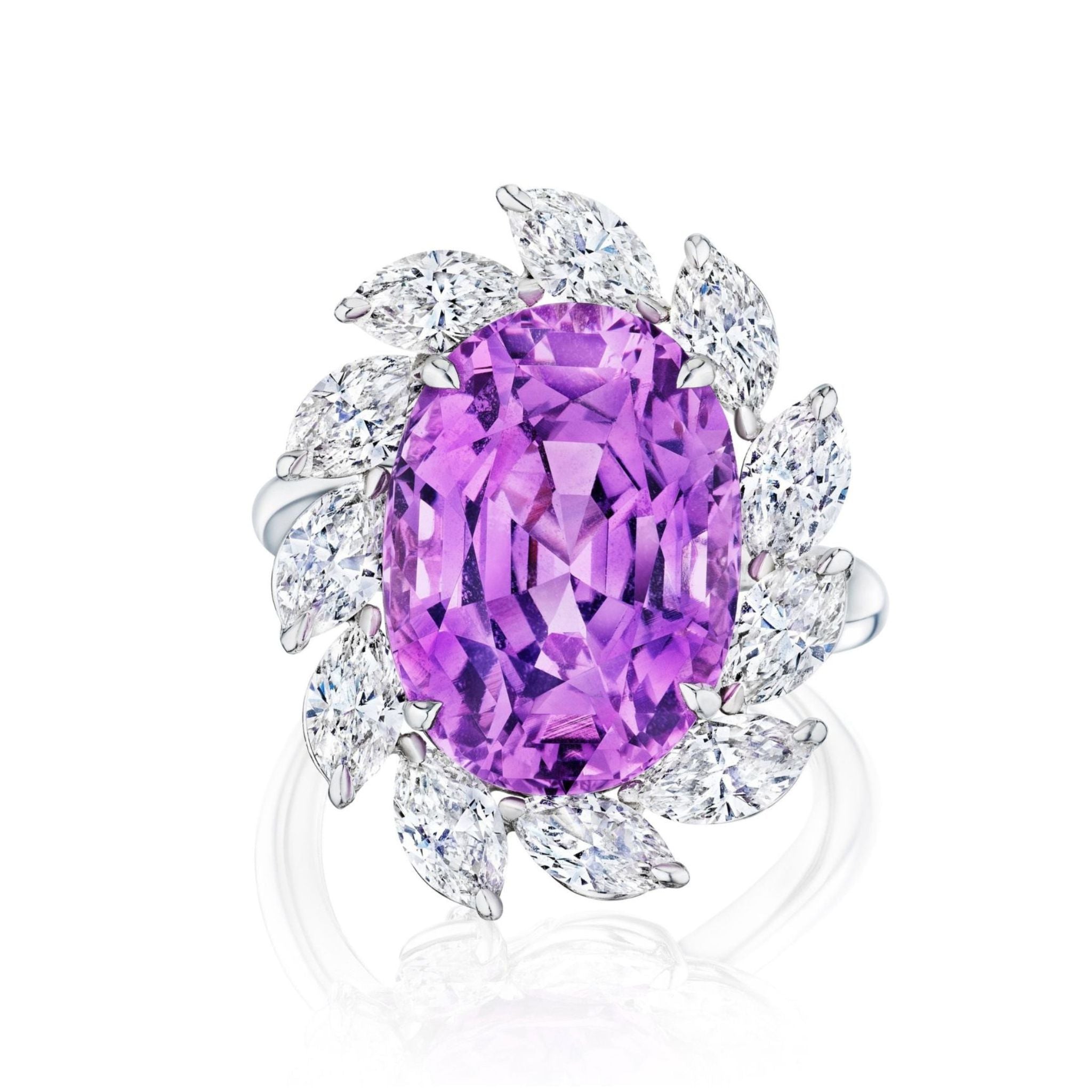 The Sunburst Cocktail Ring features a large oval sapphire centerpiece surrounded by a halo of marquise and round-cut diamonds in an elegant floral pattern.