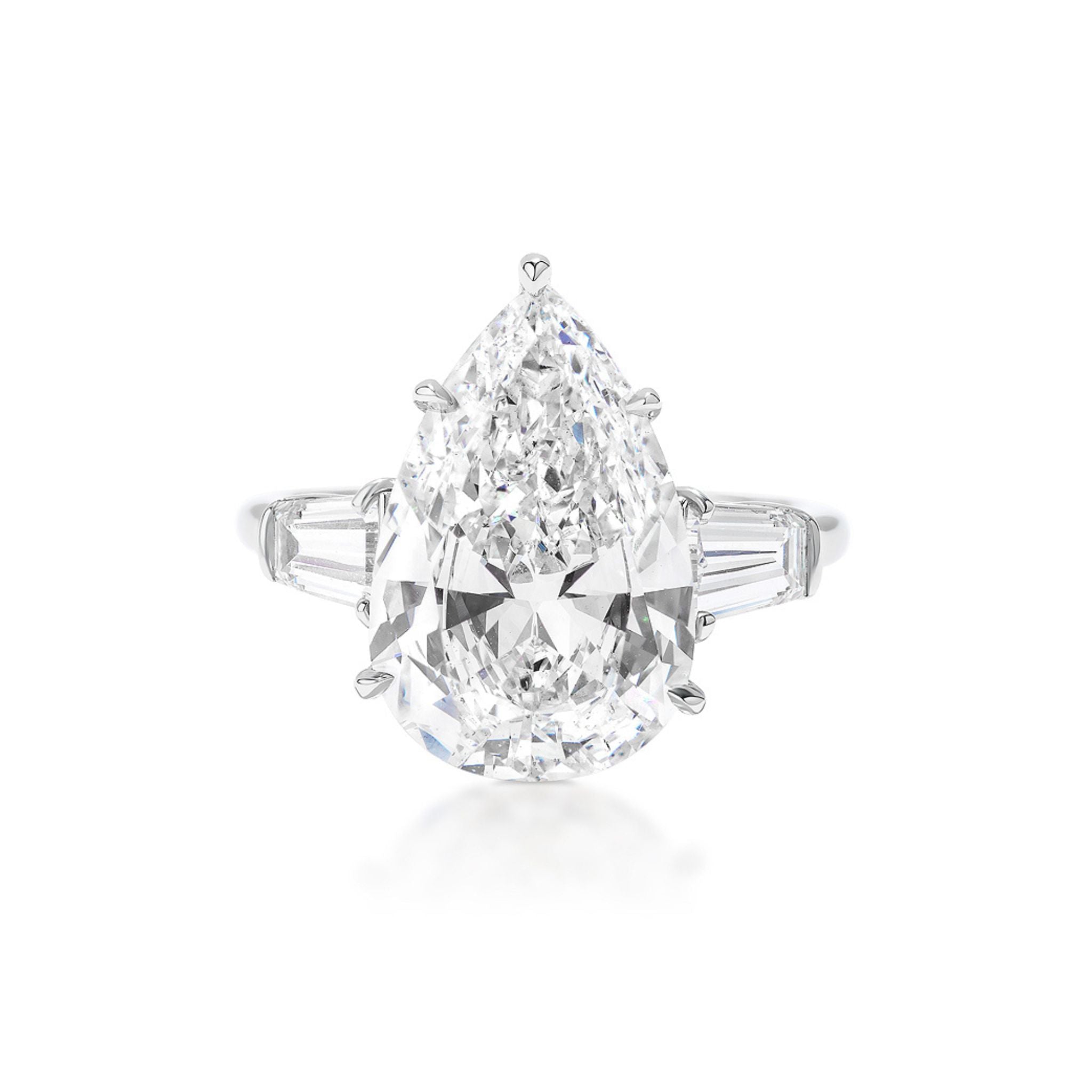 The Pear Shape Diamond Engagement Ring with Tapered Baguette Side Stones features a central pear-shaped diamond accented by two tapered baguette diamonds on each side, all set in elegant white gold.