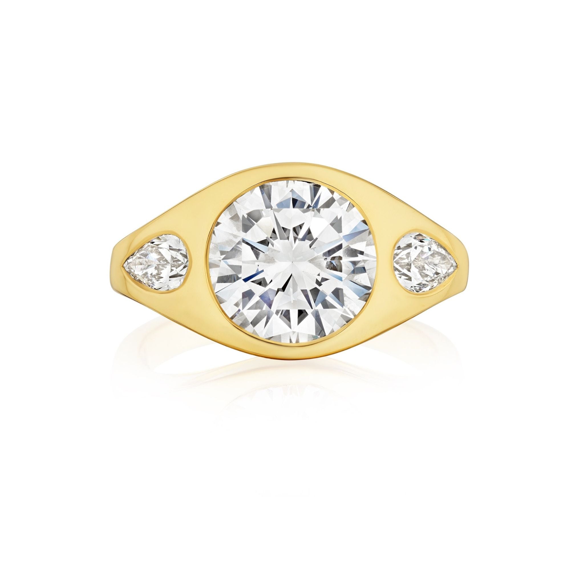 The Burnish Set Gypsy Ring features a large round diamond and two pear-shaped diamonds set in smooth, polished yellow gold.