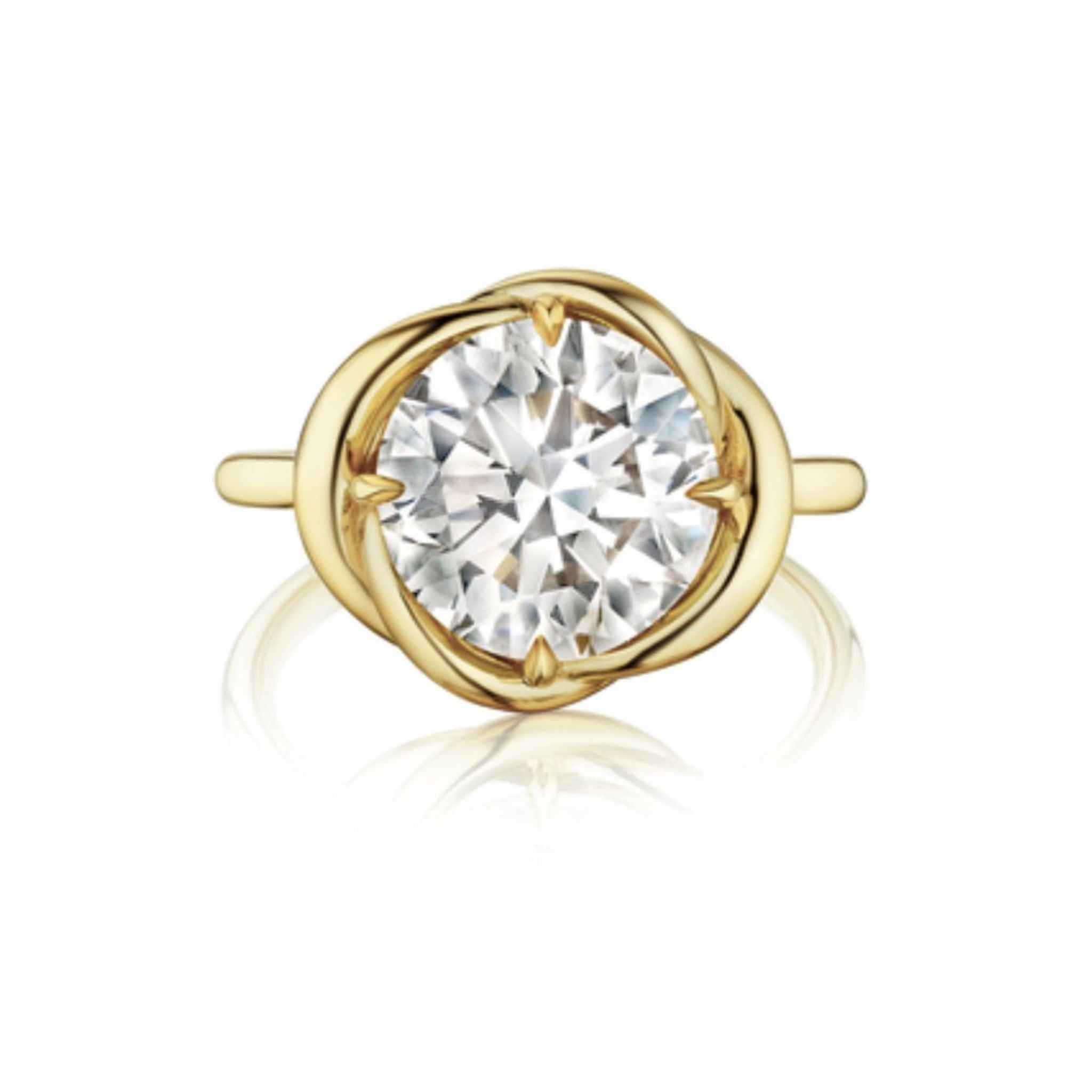 A Round Brilliant Diamond Engagement Ring with an intertwining yellow gold setting showcases a sparkling central diamond, beautifully displayed against a white background.
