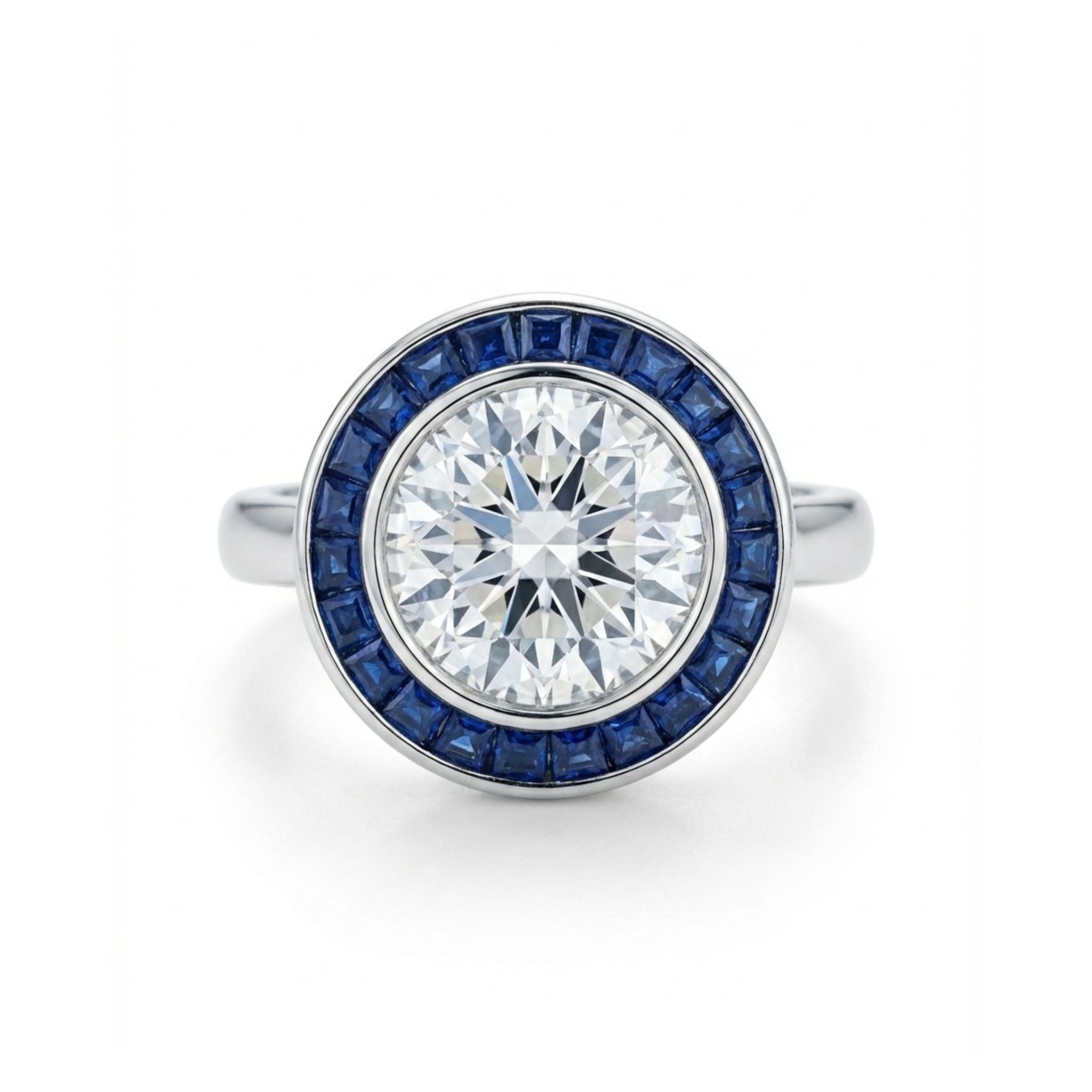 The Round Brilliant Diamond with Channel Set Sapphire Halo Ring showcases a large round diamond surrounded by a circle of deep blue sapphires, displayed on a plain white background.