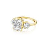 The Collet Set Cushion Cut Diamond Engagement Ring with Round Side Stones in yellow gold is showcased against a plain white background.