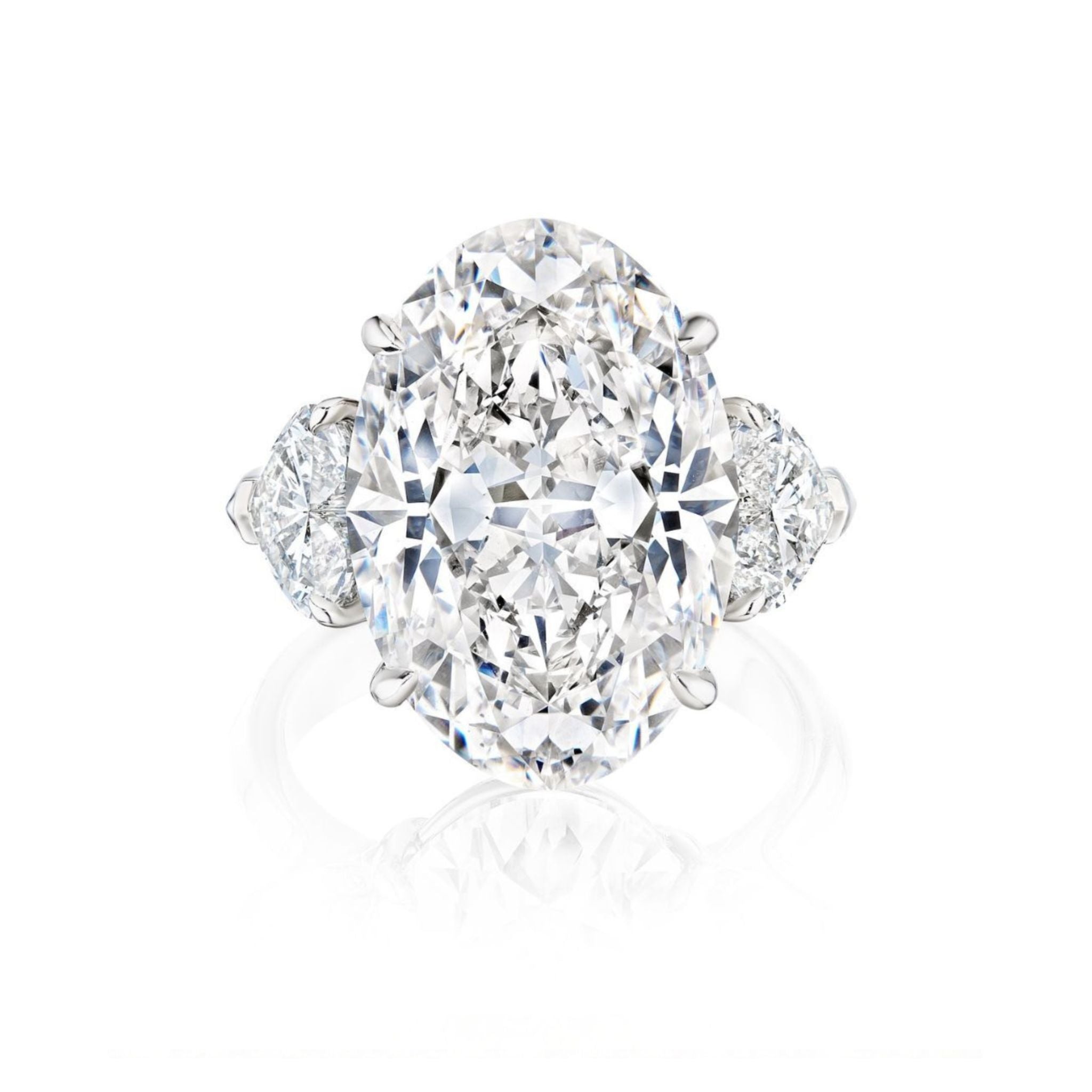 An Oval Diamond Engagement Ring with heart-shaped side stones is displayed against a white background, featuring a large oval diamond at the center and two smaller heart-shaped diamonds on each side.