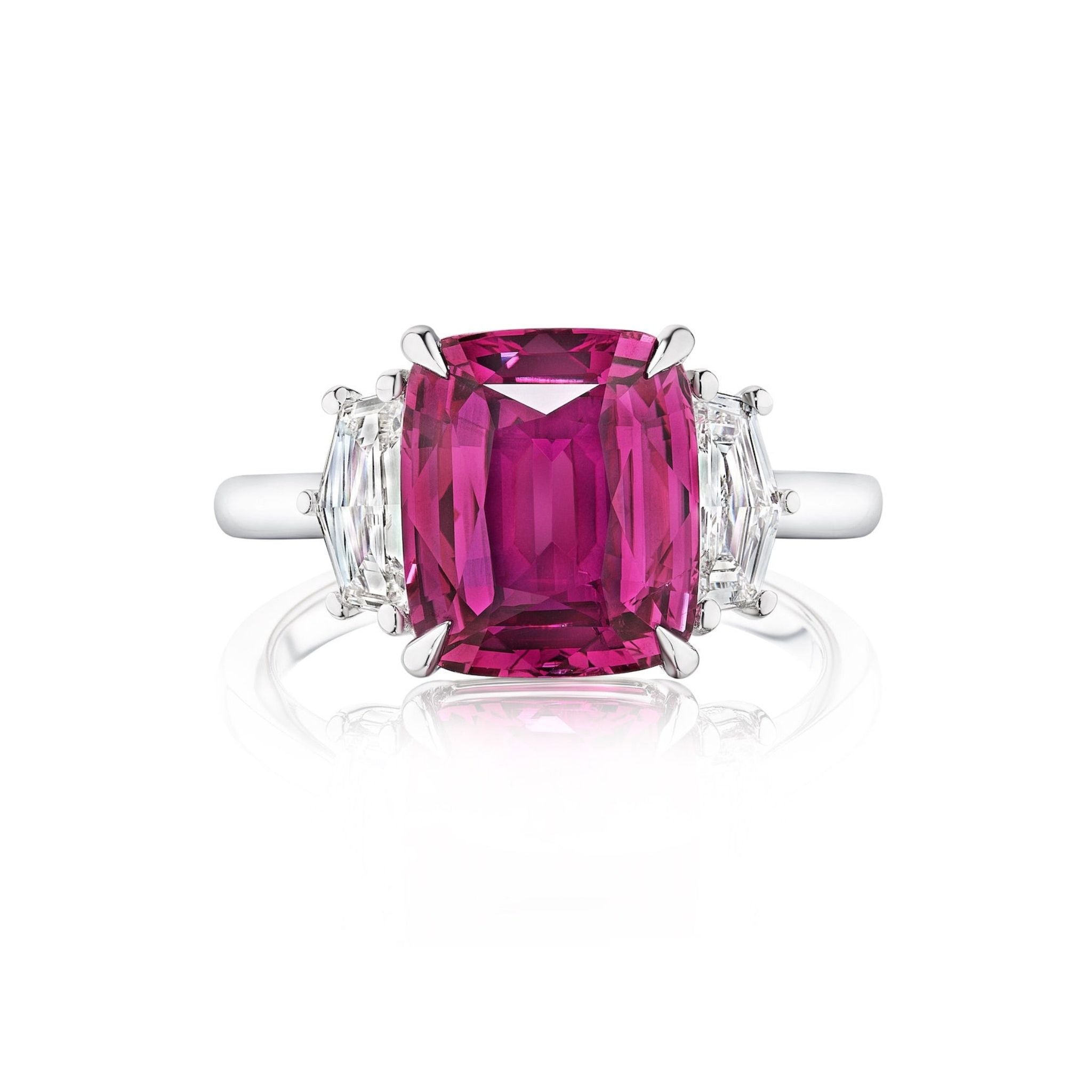 The Pink Sapphire Cushion Cut Engagement Ring in White Gold features a large cushion-cut pink sapphire center with Cadillac diamond side stones, shown against a white background.