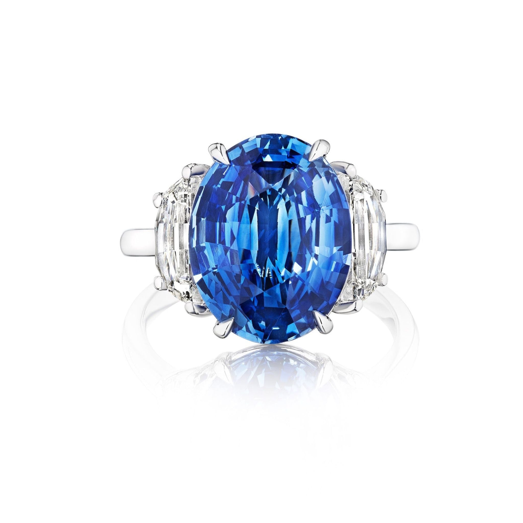 The Modified Oval Blue Sapphire Engagement Ring in Platinum features a central oval sapphire and modified half moon side stones on a simple band.