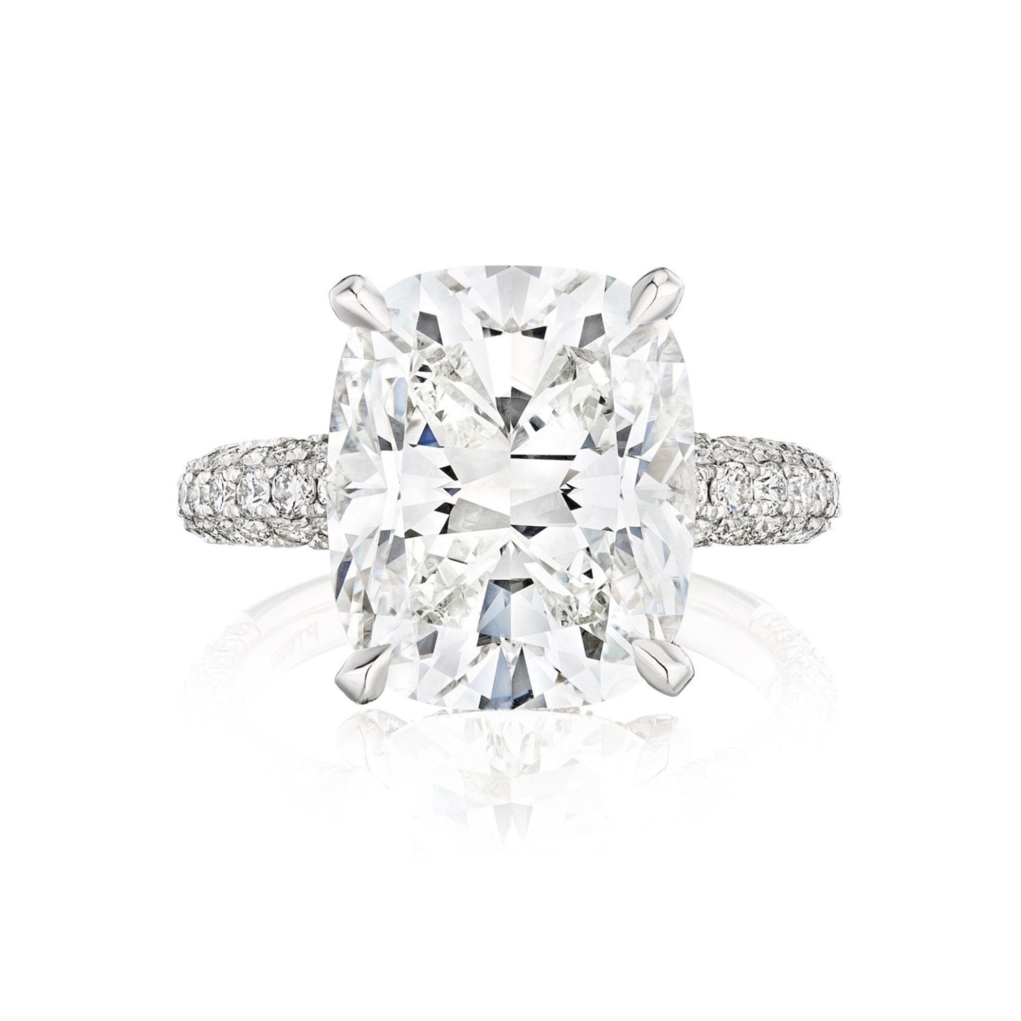 The Cushion Cut Diamond Engagement Ring with Pavé Band features a large cushion-cut diamond in a four-prong setting and a multi-tier pavé band with round diamonds, displayed on a white background.