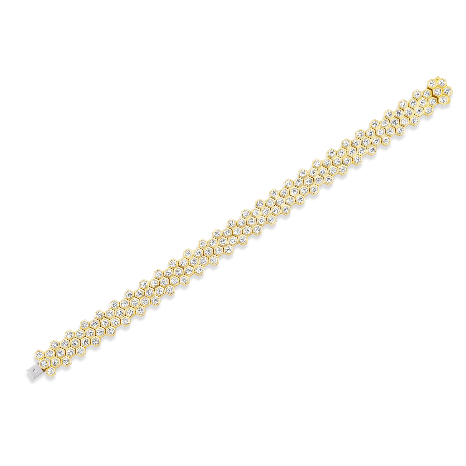 The Multi-Tier Hexagon Bezel Set Tennis Bracelet in Yellow Gold features a striking honeycomb pattern, with clusters of round diamonds set diagonally along its length and beautifully contrasted against a crisp white background.