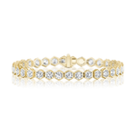 Introducing the Large Hexagon Bezel Set Diamond Tennis Bracelet: a striking piece crafted in 18K gold, showcasing hexagonal links each bezel-set with a brilliant round diamond, elegantly displayed against a white background with a soft reflection beneath.