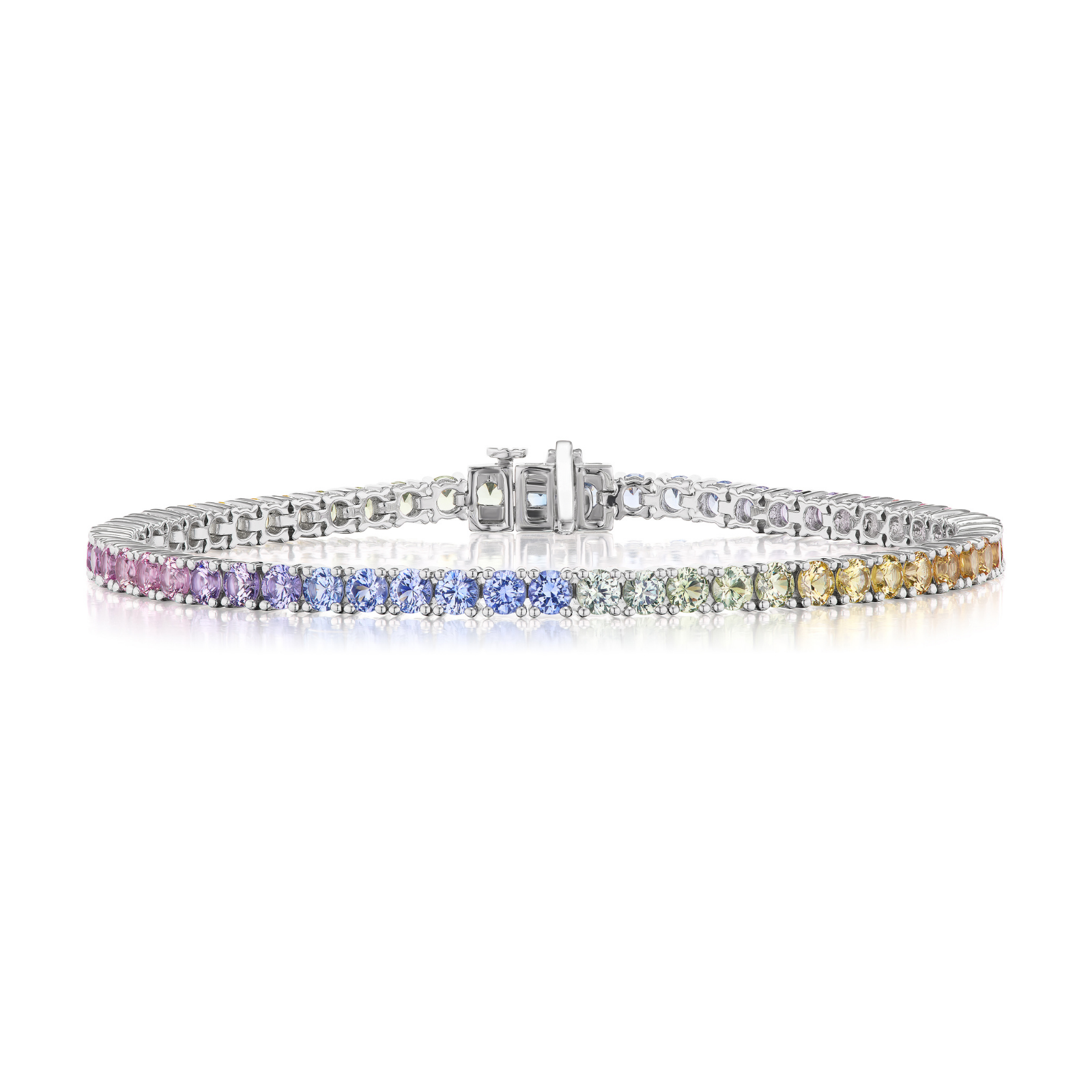 The Pastel Rainbow Tennis Bracelet is a silver piece featuring round, multi-colored sapphires arranged in a gradient from pink to purple, blue, green, and yellow, displayed on a white background.