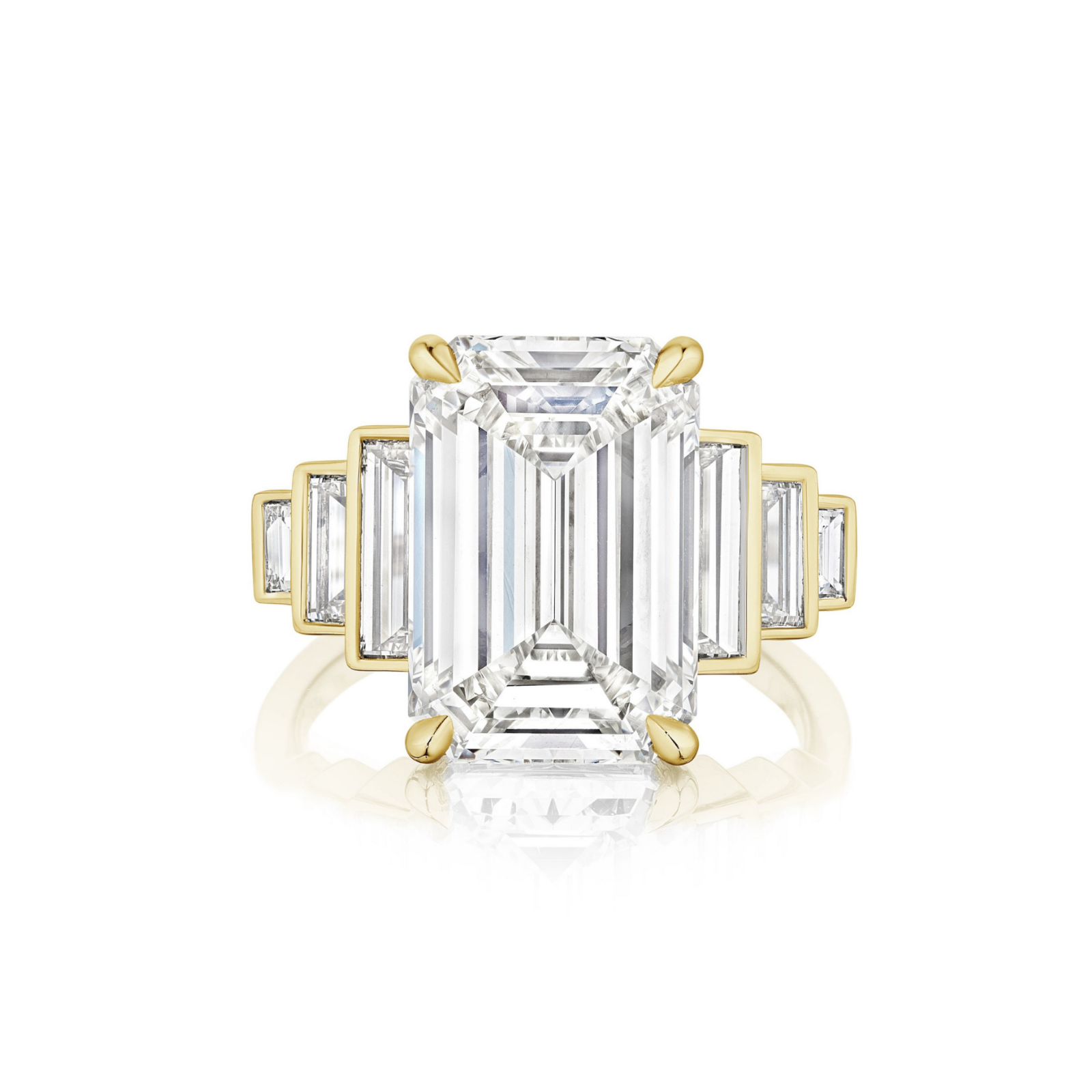 The Triple Echo Emerald Cut Diamond Engagement Ring with Bezel Set Baguette Side Stones features an 18k gold band showcasing a striking emerald-cut diamond center stone, accented by bezel-set baguette side stones on each side for a refined and symmetrical look.