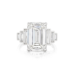 The Triple Echo Emerald Cut Diamond Engagement Ring with Bezel Set Baguette Side Stones is a breathtaking 18k gold engagement ring, showcasing a striking emerald-cut diamond at the center and accented by elegant bezel-set baguette side stones on each side, displayed against a white background.