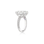 The Cushion Cut Diamond Engagement Ring with Pavé Band features a striking large cushion cut diamond centerpiece and multi-tier pavé diamonds along the band, displayed from a side angle against a white background.