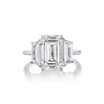 The Emerald Cut Diamond Engagement Ring with Trapezoid Side Stones showcases a striking emerald-cut diamond at its center, set in platinum and complemented by two trapezoid-cut diamonds on each side.