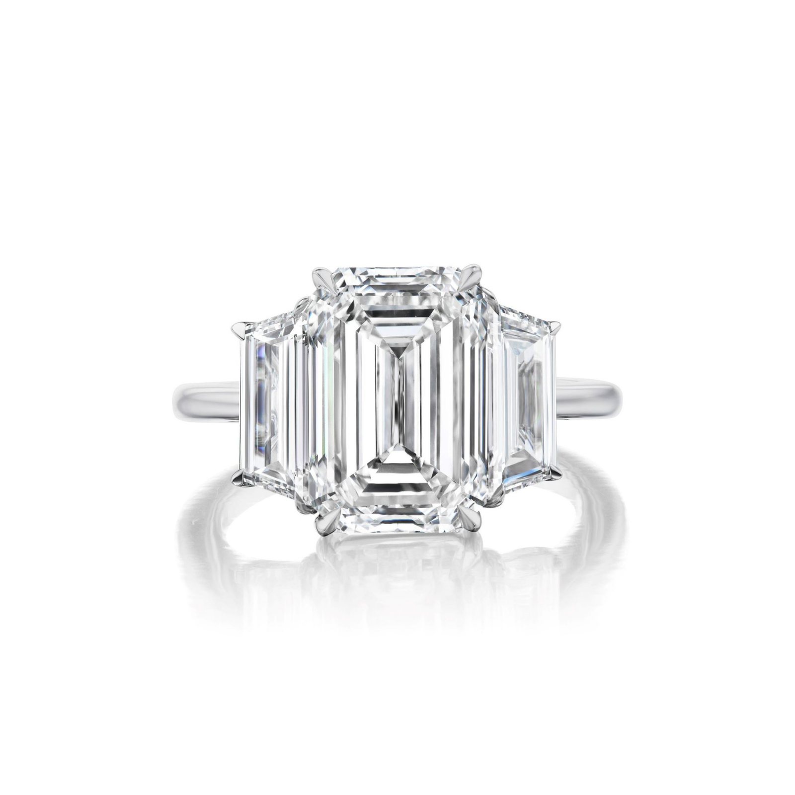 The Emerald Cut Diamond Engagement Ring with Trapezoid Side Stones showcases a striking emerald-cut diamond at its center, set in platinum and complemented by two trapezoid-cut diamonds on each side.