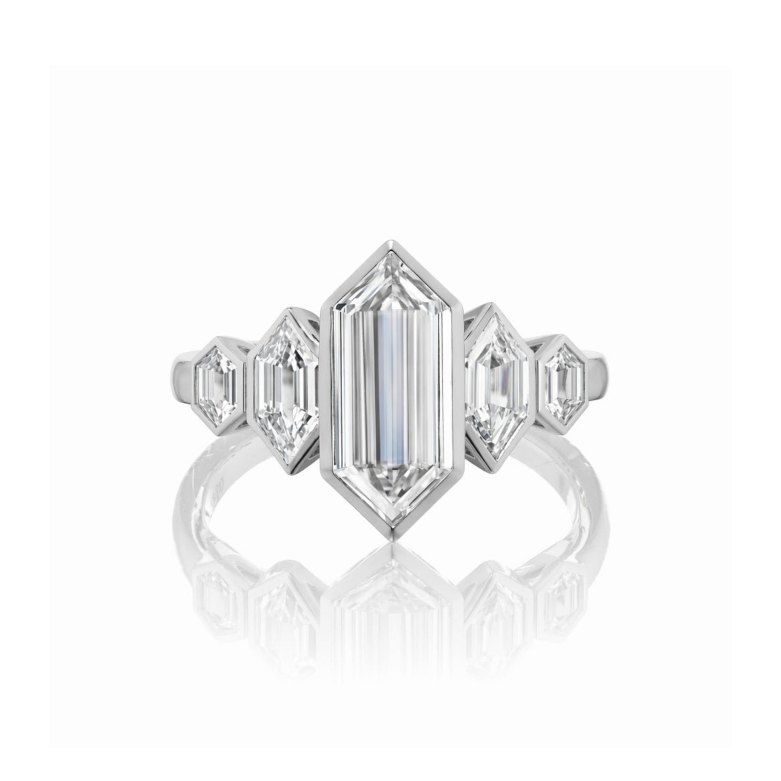 The Elongated Hexagon Diamond Engagement Ring with Side Stones features a central elongated hexagon diamond, accented by two smaller elongated hexagon diamonds and two trapezoid-shaped diamonds, elegantly displayed on a reflective white background.