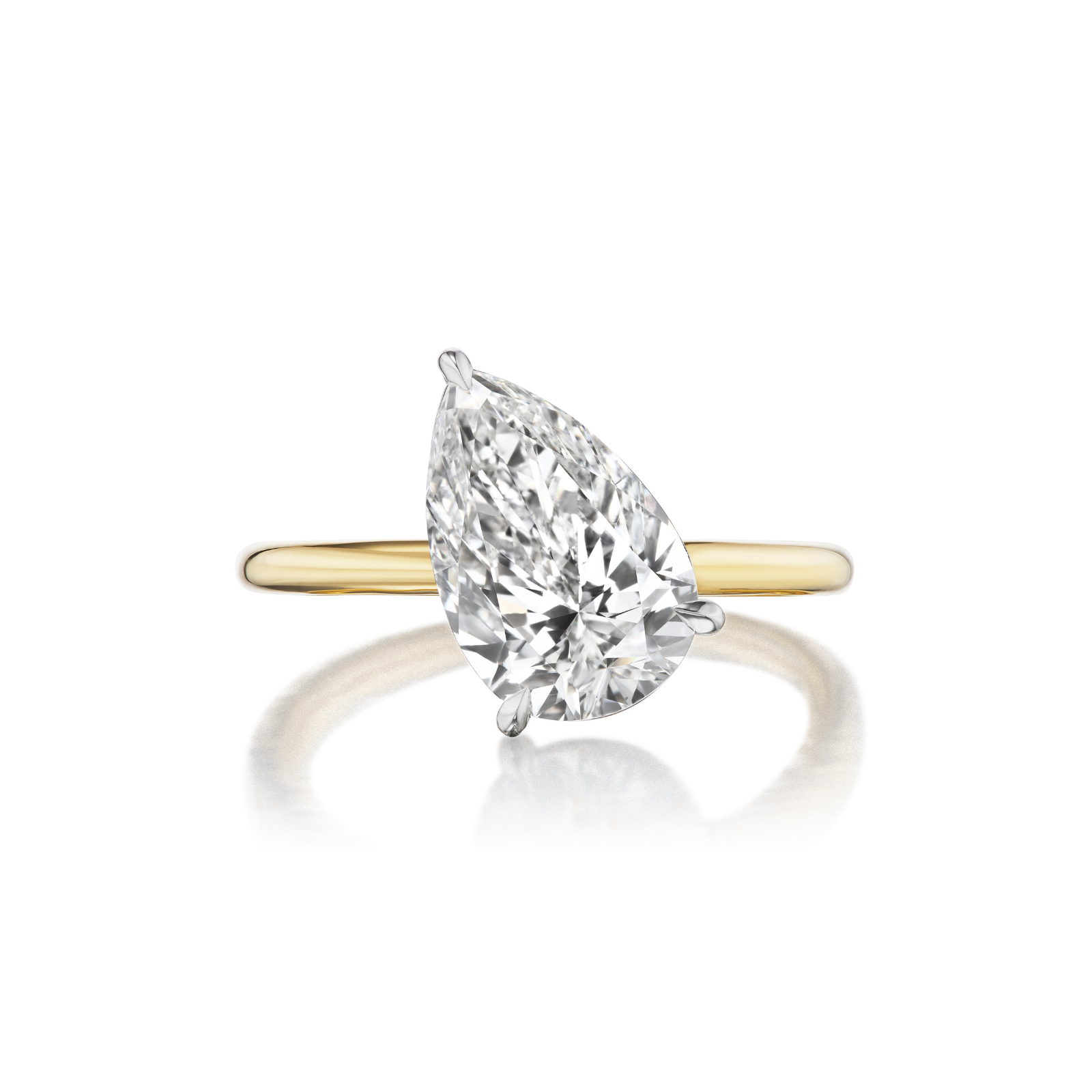 The Diagonally Set Pear Shape Diamond Engagement Ring features a large pear-shaped diamond solitaire, crafted in 18K yellow gold and displayed against a white background.