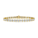 Introducing the East-West Emerald Cut Tennis Bracelet: a stunning 18K gold bracelet showcasing a continuous row of emerald cut diamonds set in prongs, secured by a central clasp. Elegantly presented against a white background.