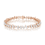 The Mixed Shape Diamond Tennis Bracelet showcases alternating oval and emerald-cut white gemstones of G-H color and SI+ clarity, set in 18k rose gold. Displayed elegantly on a white reflective surface, this expertly crafted piece embodies sophistication and timeless appeal.