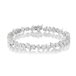 The Mixed Shape Diamond Tennis Bracelet showcases an array of diamond cuts set in radiant 18k gold, secured with a sturdy clasp and elegantly displayed against a reflective white surface. Adorned with G-H color, SI+ clarity diamonds, this bracelet exudes a timeless and exquisite shimmer.