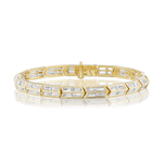 Chrysler Baguette Diamond Tennis Bracelet featuring hexagonal links, each adorned with baguette-cut diamonds, expertly crafted in 18k yellow gold and showcased on a reflective white surface.