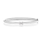 Introducing the East-West Set Emerald Cut Diamond Bangle: a chic 18K white gold bracelet featuring a centrally set, rectangular emerald-cut diamond of VS2 clarity, showcased against a white background with a gentle reflection beneath.