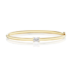 The East-West Set Emerald Cut Diamond Bangle is a slender bracelet crafted from 18K white gold, showcasing a centrally set emerald cut diamond of VS2 clarity, presented against a white background.