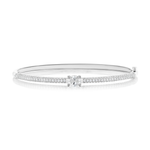 The East-West Set Oval Shape Diamond Pavé Bangle is a delicate 18k gold bangle showcasing an oval-shaped center diamond, surrounded by two rows of pavé-set diamonds, beautifully displayed on a white background.