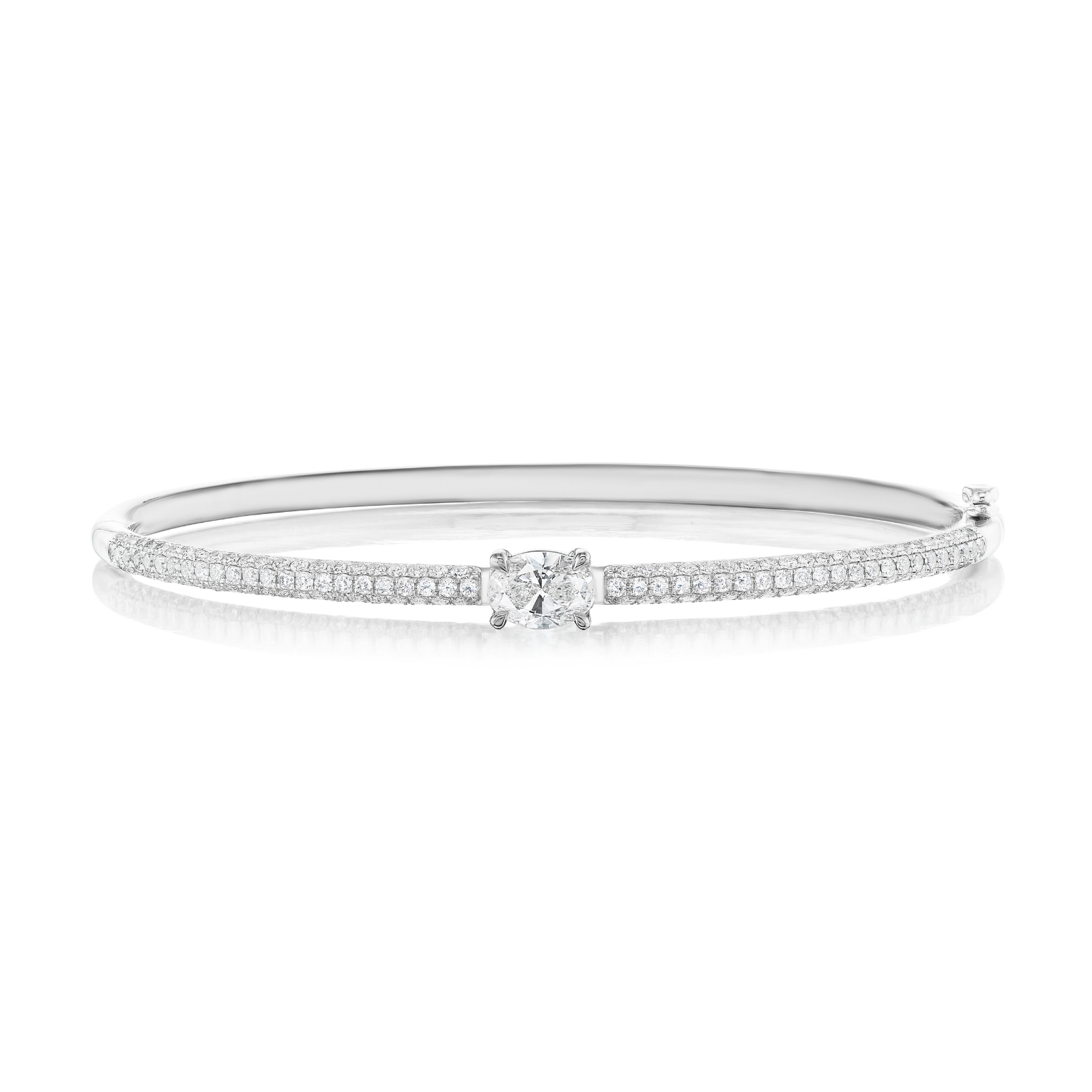 The East-West Set Oval Shape Diamond Pavé Bangle is a delicate 18k gold bangle showcasing an oval-shaped center diamond, surrounded by two rows of pavé-set diamonds, beautifully displayed on a white background.