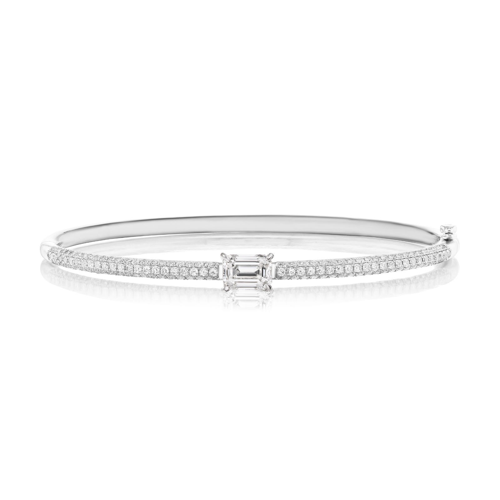 Introducing the East-West Set Emerald Cut Diamond Pavé Bangle: a silver bangle bracelet adorned with two rows of pavé diamonds and highlighted by a striking rectangular emerald-cut diamond at its center.