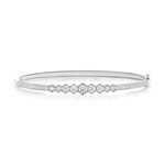 The Graduated Hexagon Bezel Set Diamond Pavé Bangle, a sleek silver bracelet showcased against a white background, features a row of SI clarity round-cut diamonds set in graduated hexagon bezels at the center and pavé-set diamonds adorning the band.