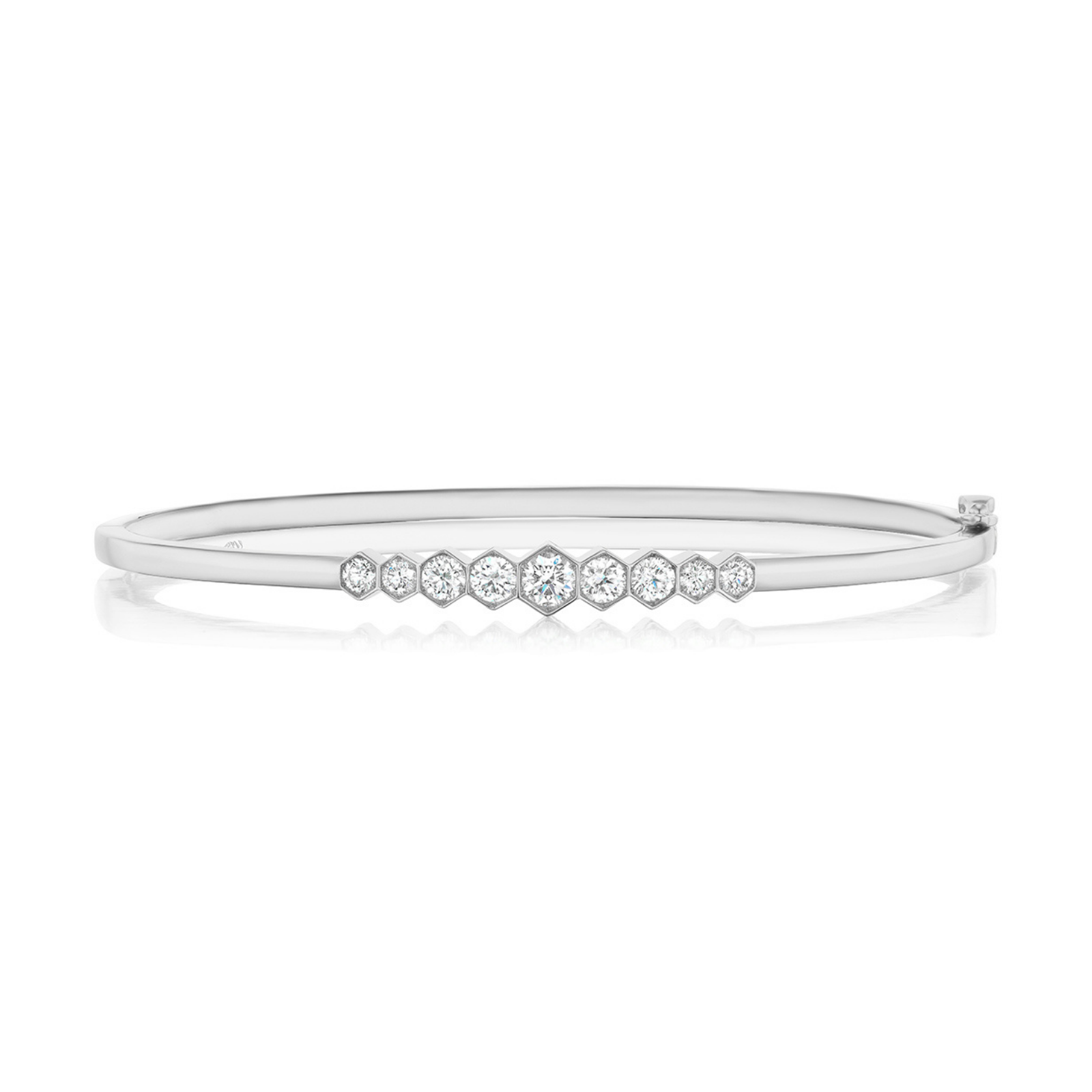 The Graduated Hexagon Bezel Set Diamond Bangle showcases a row of nine round, graduated diamonds at its center, offering an elegant and minimalist design reminiscent of a classic bezel set diamond bangle.