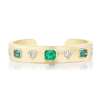 Bezel Set Mixed Shape Diamond and Emerald Bangle in Yellow Gold features alternating rectangular emeralds and heart-shaped diamonds, all elegantly set in luxurious 18K yellow gold and displayed against a white background.