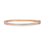 The Hexagon Bezel Set Diamond Bangle is a slim 18k gold bracelet adorned with a single row of round brilliant diamonds set in bezels, featuring a distinctive hexagonal pattern along the inner edge.