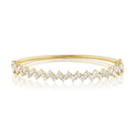 A Zig Zag Motif Emerald Cut Diamond Bangle crafted in yellow 18k gold is displayed on a white background. The bangle's band showcases a continuous row of emerald-cut, VS clarity diamonds set in a repeating zig-zag pattern, with its reflection visible on the surface below.