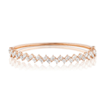 Introducing the Zig Zag Motif Emerald Cut Diamond Bangle: an elegant rose gold bracelet showcasing a row of diagonally set, emerald cut VS clarity diamonds. These closely arranged diamonds shimmer in luxurious 18k gold, creating a sparkling, sophisticated design.