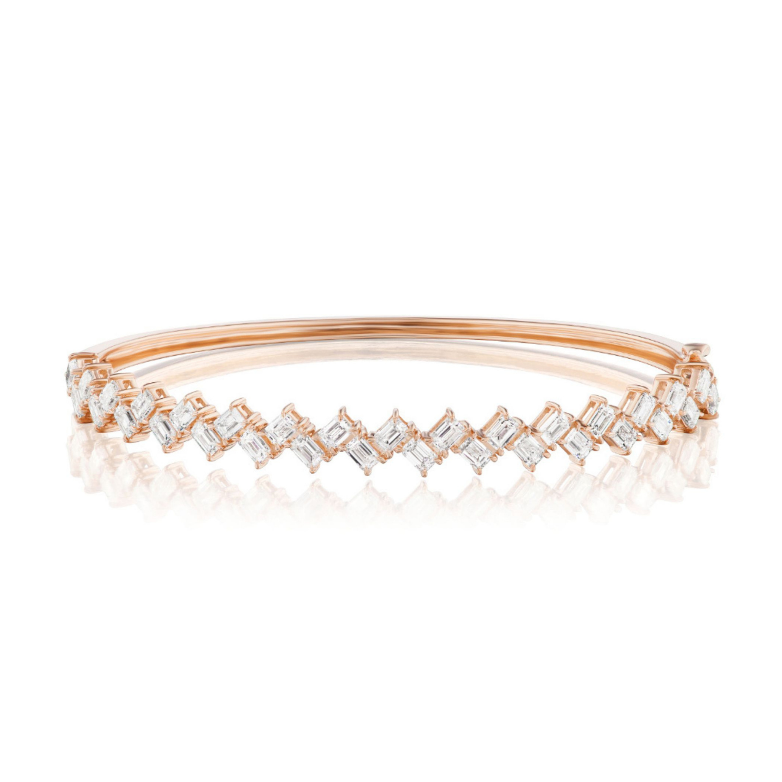 Introducing the Zig Zag Motif Emerald Cut Diamond Bangle: an elegant rose gold bracelet showcasing a row of diagonally set, emerald cut VS clarity diamonds. These closely arranged diamonds shimmer in luxurious 18k gold, creating a sparkling, sophisticated design.
