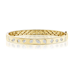 The Burnish Set Mixed Shape Diamond Bangle, crafted in 18K gold and adorned with mixed shape diamonds encircling the band, features a geometric patterned inner side and is displayed on a white reflective surface.