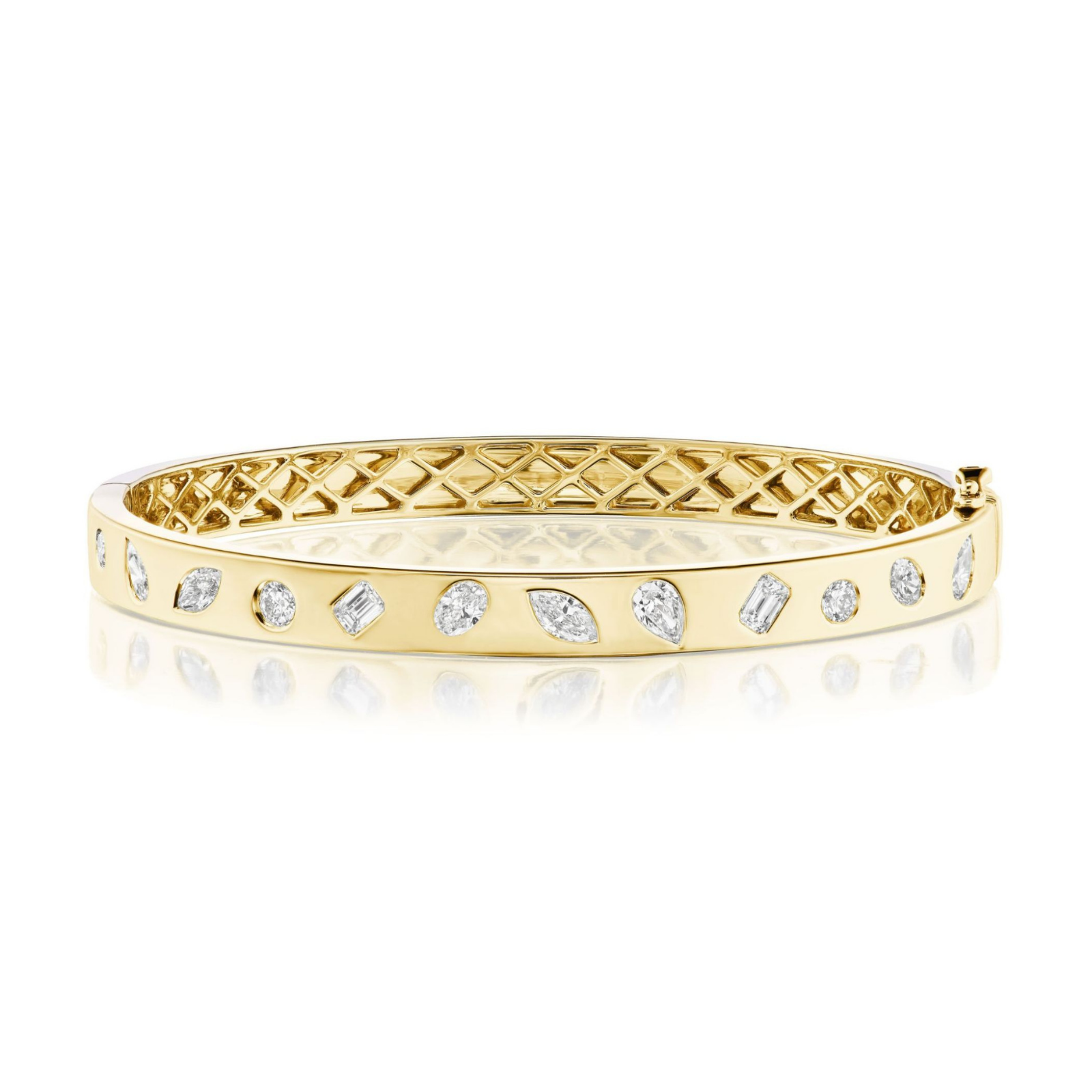 The Burnish Set Mixed Shape Diamond Bangle, crafted in 18K gold and adorned with mixed shape diamonds encircling the band, features a geometric patterned inner side and is displayed on a white reflective surface.
