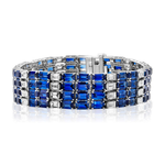 Introducing the Sapphire and Diamond Striped Evening Bracelet: an exquisite piece crafted in 18K white gold, showcasing three rows of alternating rectangular blue sapphires and sparkling diamonds, all secured with a central clasp.