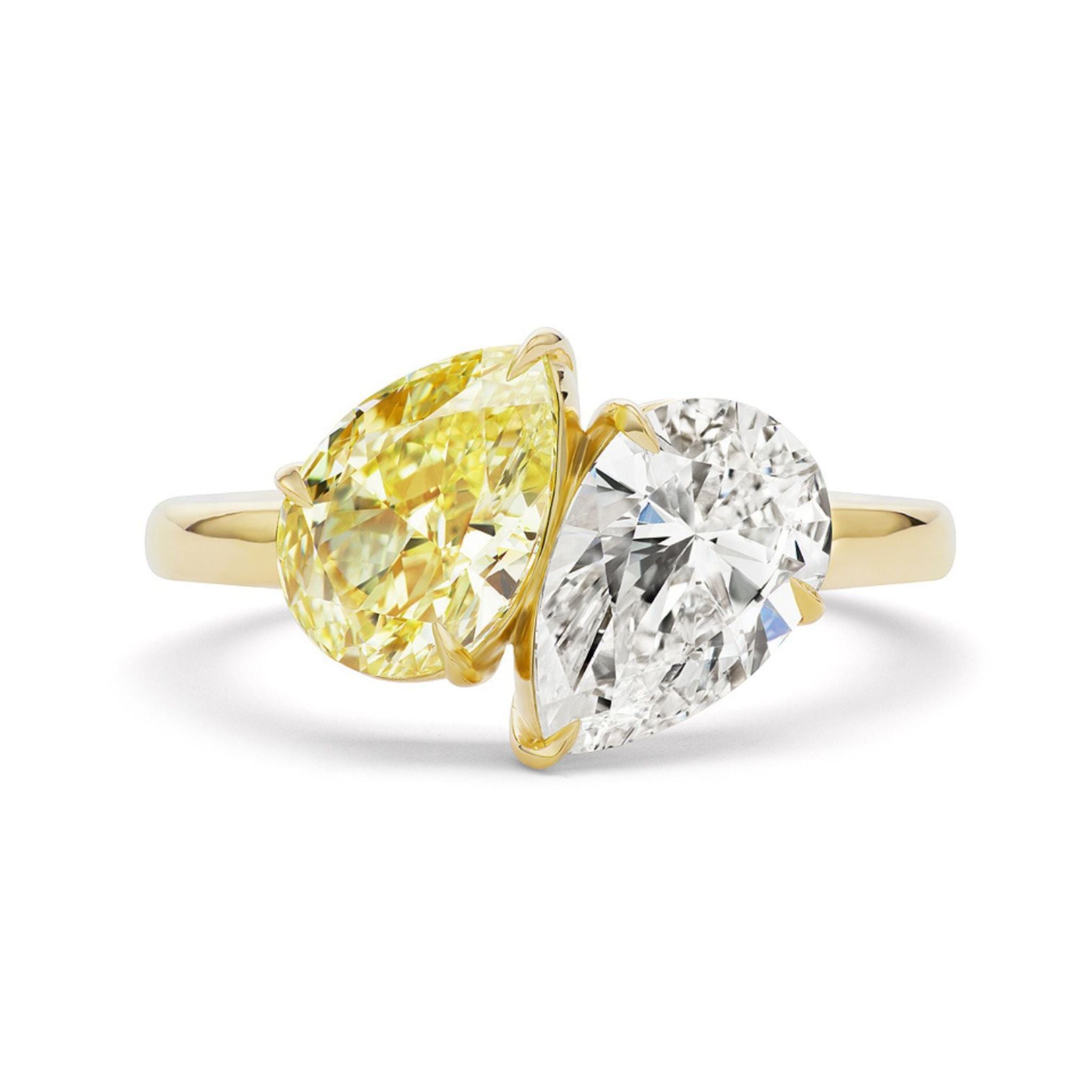 The Toi Et Moi Ring showcases two pear-shaped diamonds—one fancy yellow and one white—set side by side in opposite directions for a striking engagement ring design.
