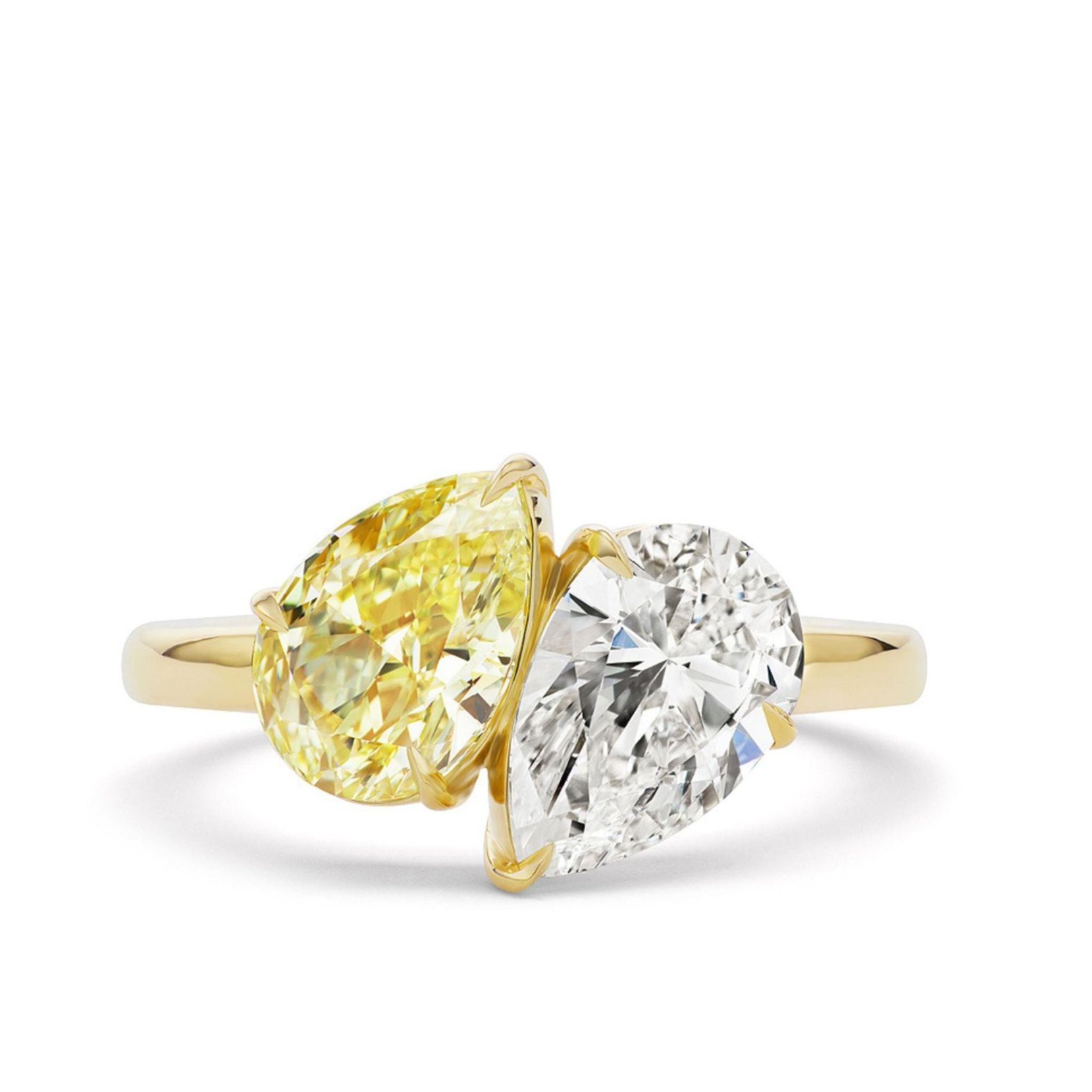 The Toi Et Moi Ring features a unique, modern design with two pear-shaped diamonds—one fancy yellow and one white—set side by side, showcased against a white background.