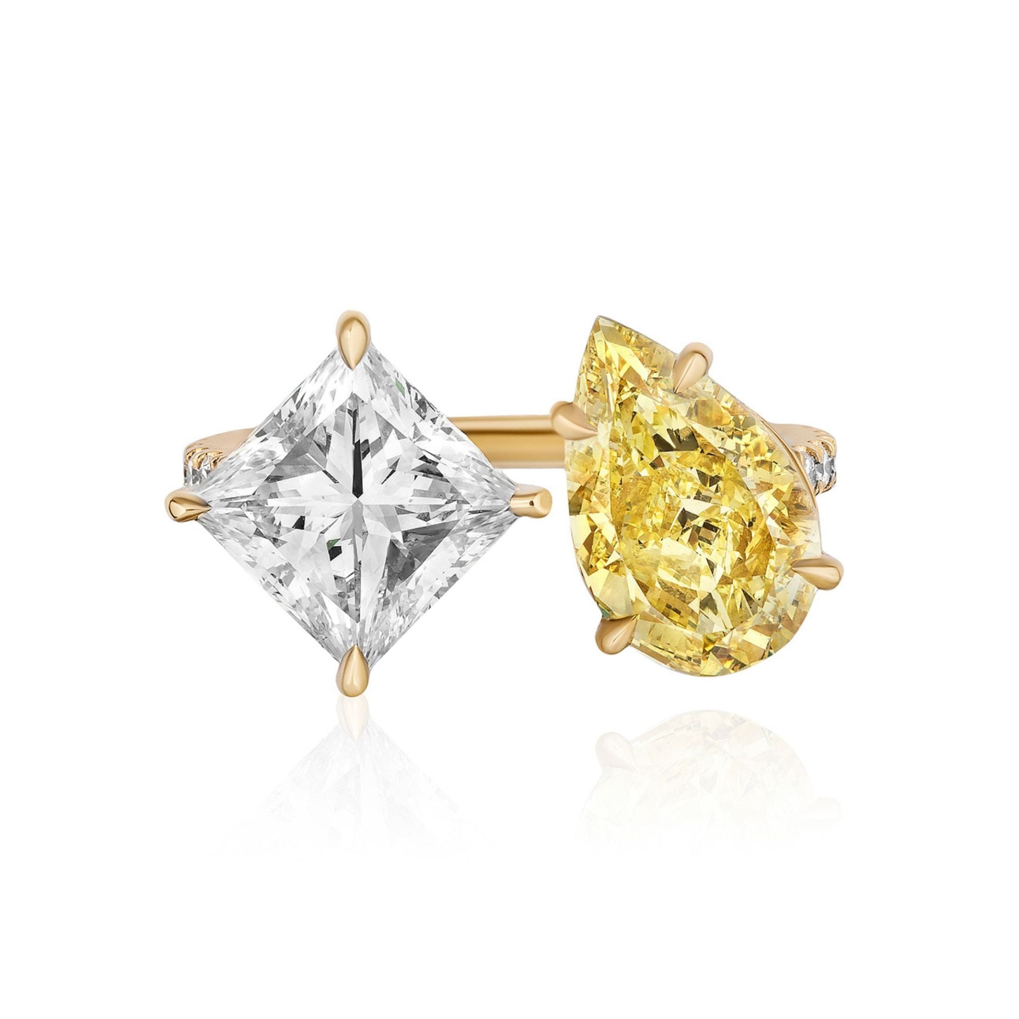 A gold Toi et Moi Pavé Ring featuring a fancy yellow pear-shaped diamond and a white princess cut diamond, each secured by four prongs, displayed against a white background.