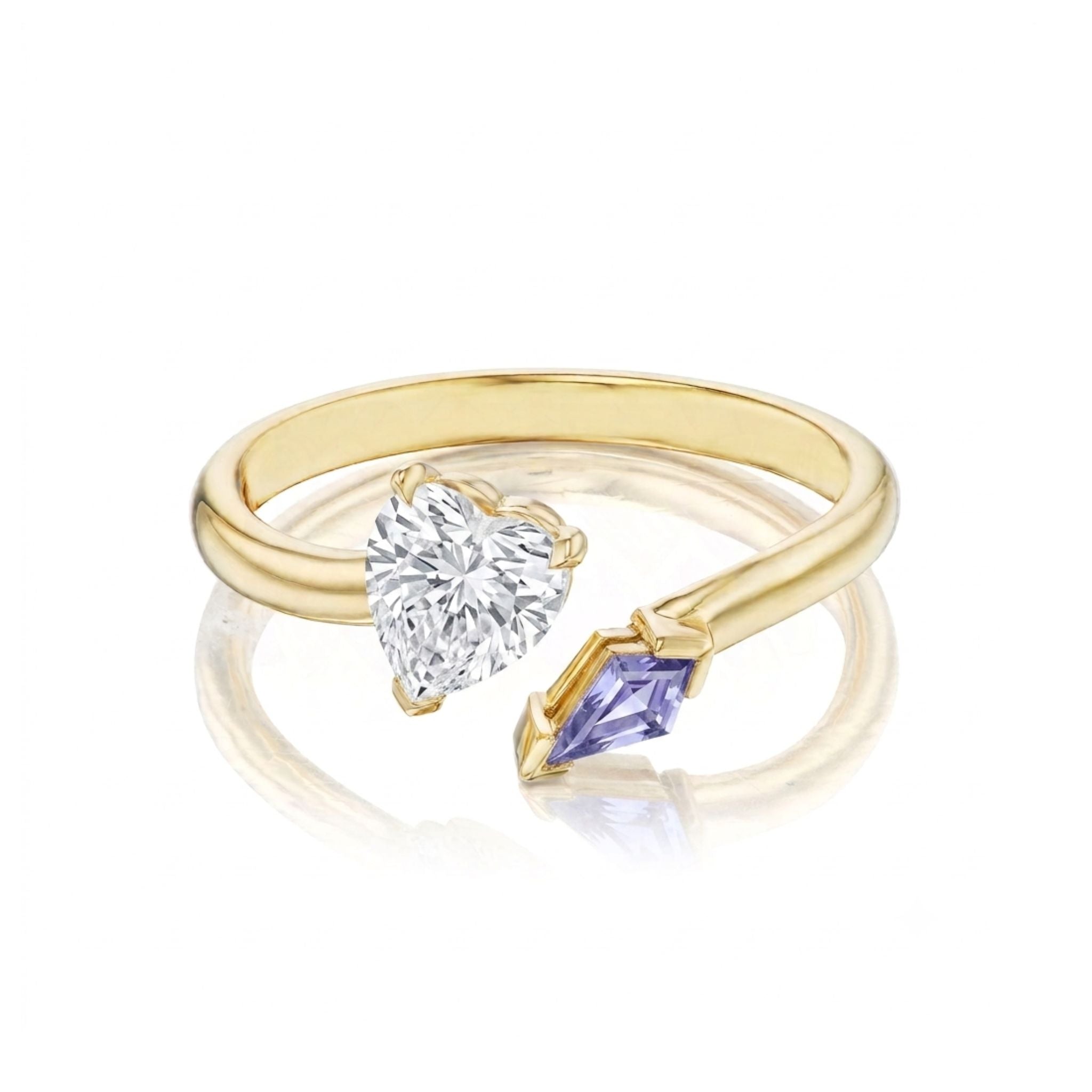 A striking Toi et Moi Ring with a heart shape diamond and a kite-shaped sapphire in yellow gold is elegantly displayed against a crisp white background, featuring the two stones set side by side on an open band.