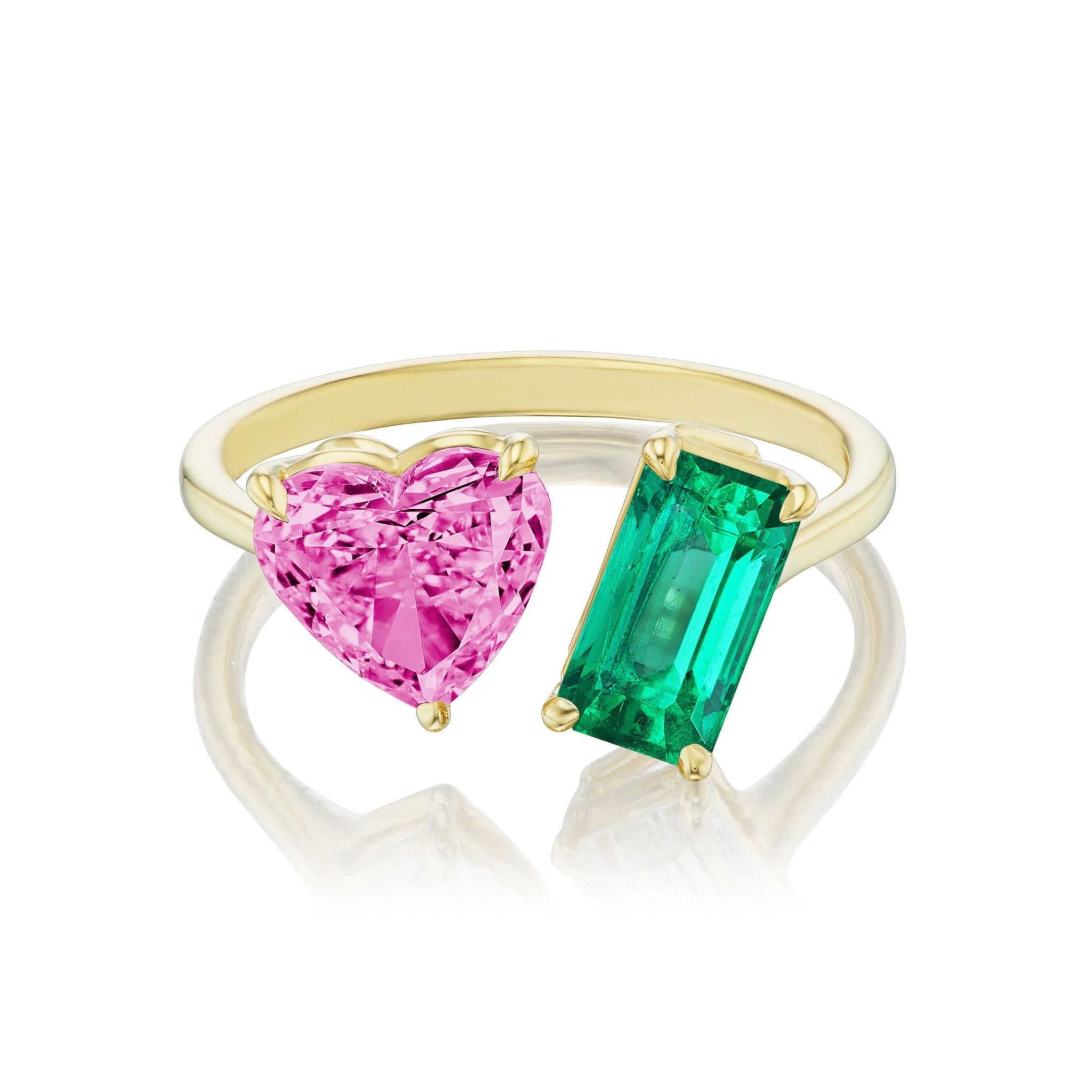 The Toi et Moi Ring showcases a pink heart-shaped sapphire and an emerald-cut emerald set side by side, beautifully crafted in 18k yellow gold.