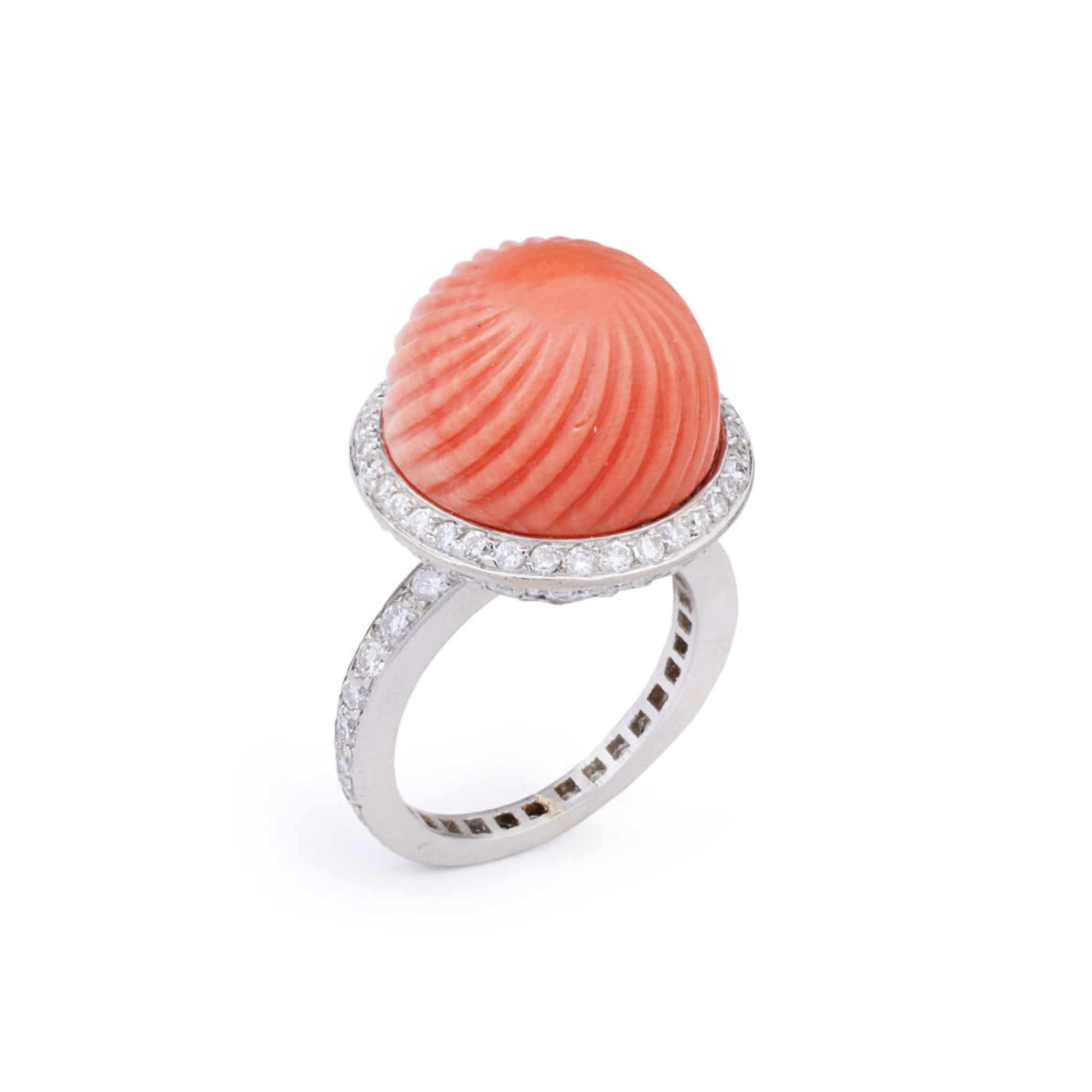 The Cartier Carved Coral and Diamond Ring showcases a round coral cabochon at its center, accented by a halo of pavé diamonds.