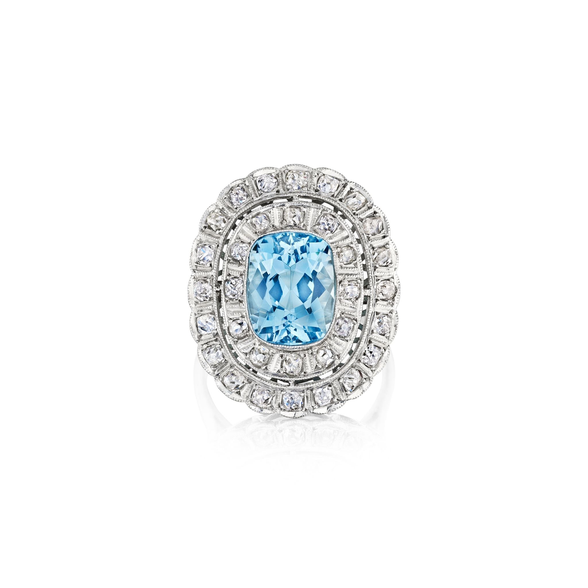 The Aquamarine and Diamond Ring features a large oval light blue aquamarine center stone, encircled by two shimmering diamond rows on a platinum or white gold band, inspired by antique designs.