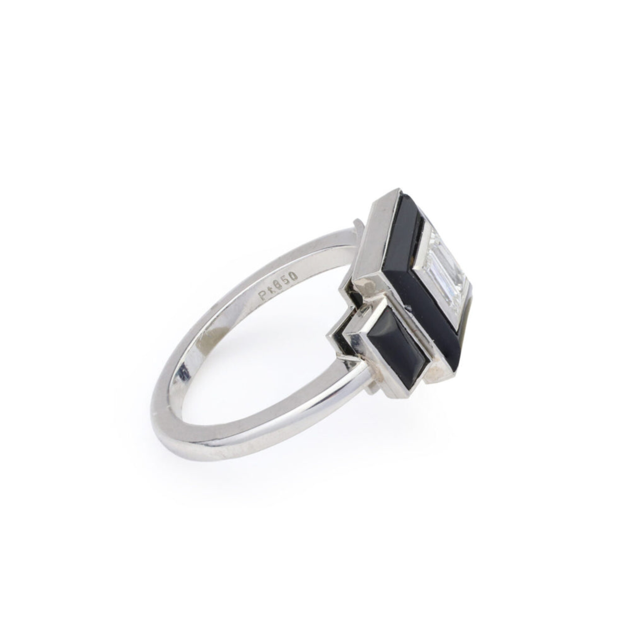 The Onyx and Diamond Ring showcases a geometric platinum design with a rectangular diamond center, framed by onyx and displayed on a white background.